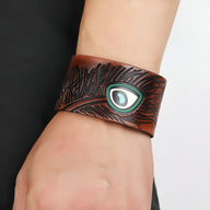 Bracelet large en cuir marron avec gravure effet bois et motif œil floral turquoise et blanc.