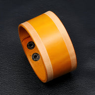 Bracelet large en cuir cognac avec bordure beige, style rétro pour homme, fermeture boutons pression noire.