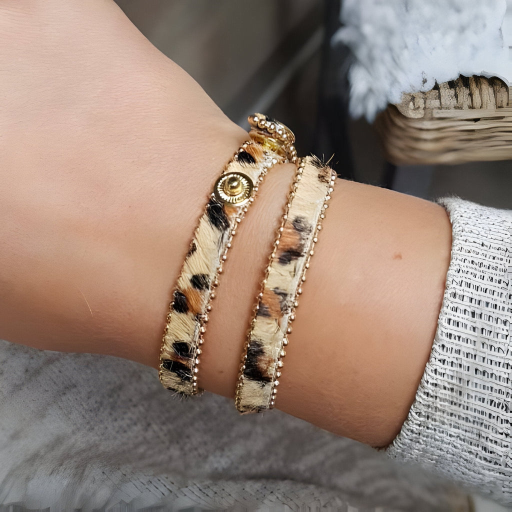 Bracelet léopard en microfibre marron avec bouton-pression doré et bordure en biais fin doré.