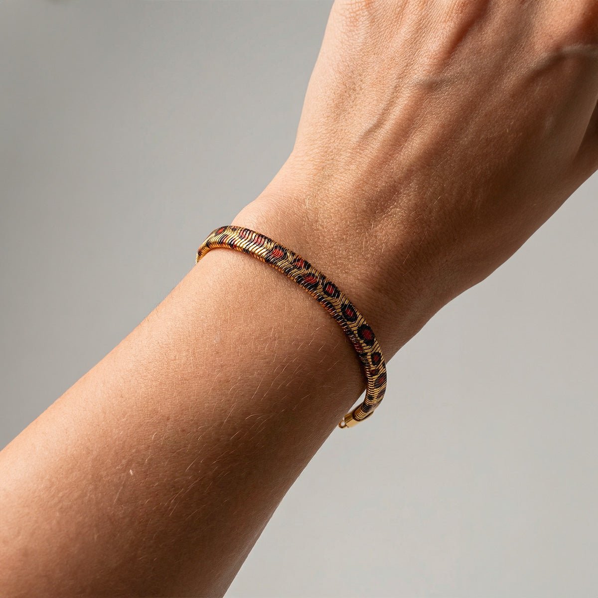Bracelet fin doré en acier inoxydable avec motif léopard et maille serpent, fermoir mousqueton.