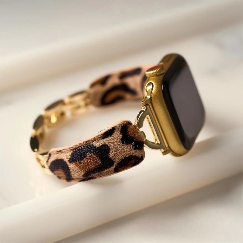 Bracelet Apple Watch léopard beige et noir à texture poils, boucles dorées brillantes, style audacieux.