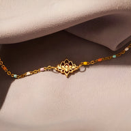 Bracelet fin en argent sterling avec pendentif fleur de lotus doré sur chaîne délicate.