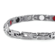 Bracelet magnétique en titane argenté pour femme avec maillons ornés de petits cristaux.