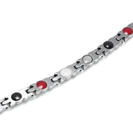 Bracelet en titane argenté avec pastilles noires, blanches et rouges, design magnétique élégant.