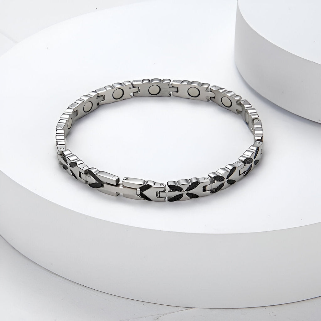 Bracelet magnétique en titane argenté avec maillons gravés et aimants visibles côté intérieur.