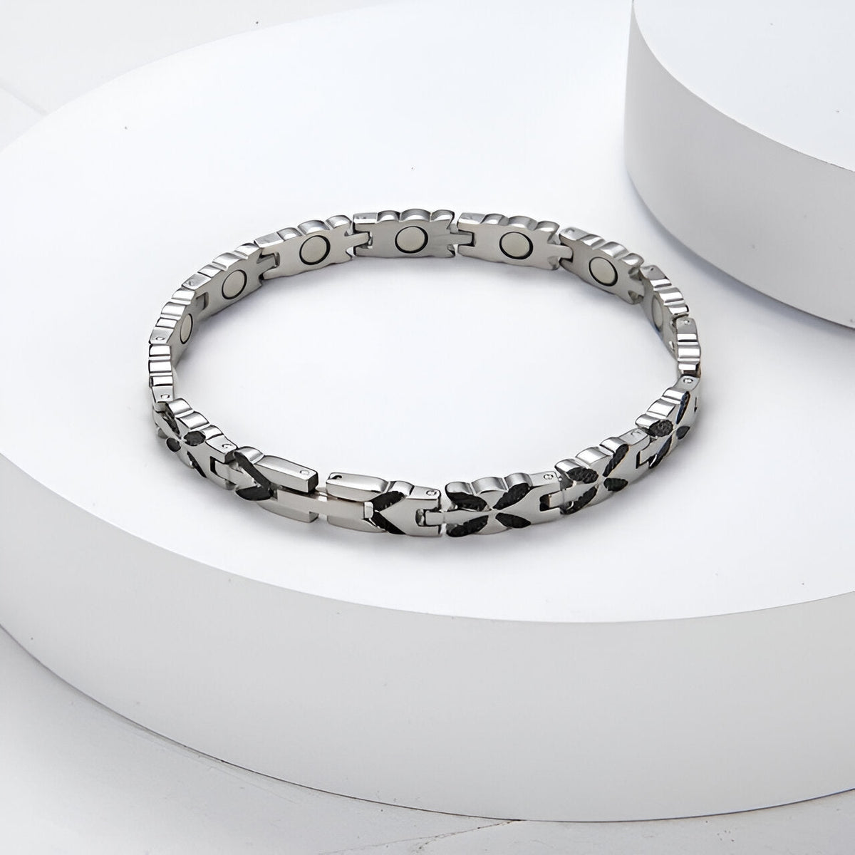 Bracelet magnétique en titane argenté avec maillons gravés et aimants visibles côté intérieur.