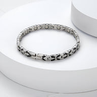 Bracelet magnétique en titane argenté avec maillons gravés et aimants visibles côté intérieur.