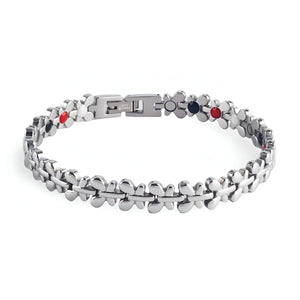 Bracelet magnétique Idunn en acier inoxydable argenté avec maillons arrondis et pastilles noires et rouges.