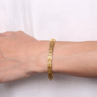 Bracelet magnétique en titane doré pour homme avec maillons en forme de chevrons.