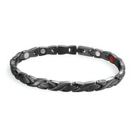 Bracelet magnétique en titane noir mat avec maillons incurvés et éléments tourmaline rouge.