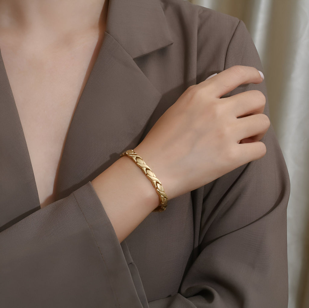 Bracelet magnétique Groa en titane or avec maillons élégants porté au poignet féminin.
