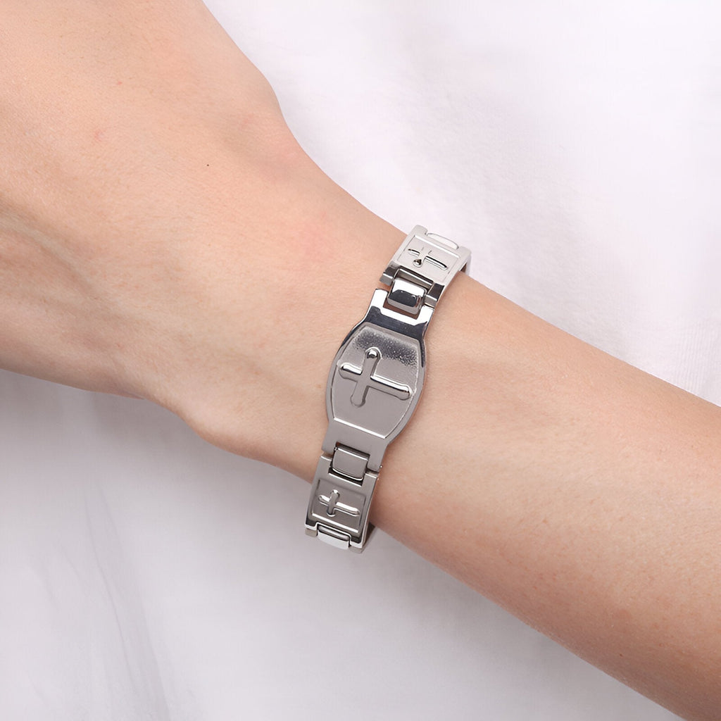 Bracelet magnétique en titane argenté avec croix chrétienne sur poignet homme.
