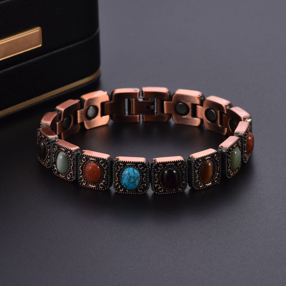 Bracelet en cuivre avec maillons larges ornés de pierres naturelles turquoise et marron sur fond noir.