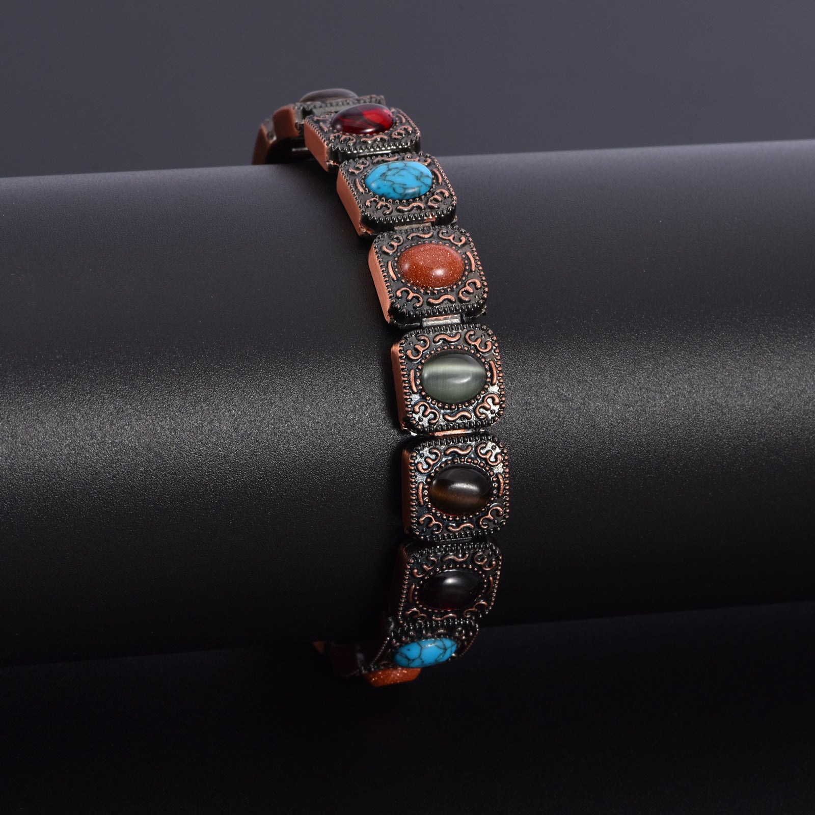 Bracelet en cuivre avec maillons ornés de pierres naturelles multicolores et détails gravés élégants.