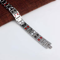 Bracelet magnétique homme en acier inoxydable argenté avec accents rouges intégrés.