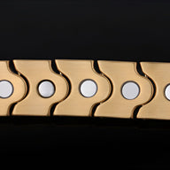 Bracelet magnétique en acier inoxydable doré avec pastilles circulaires argentées, design moderne.