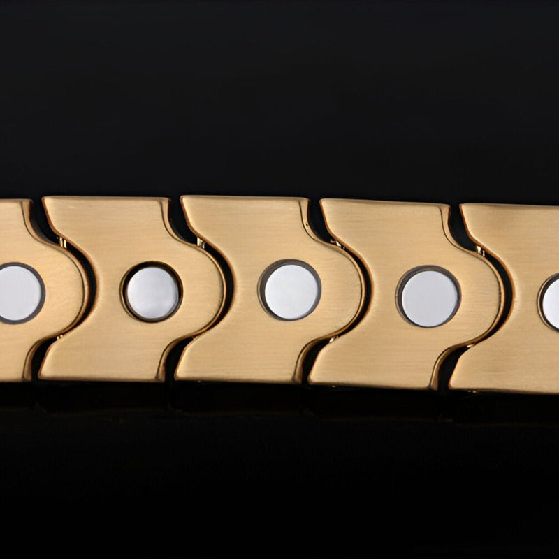 Bracelet magnétique en acier inoxydable doré avec pastilles circulaires argentées, design moderne.