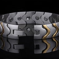 Bracelet magnétique homme en acier inoxydable argenté avec ondulations dorées élégantes.