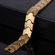 Bracelet magnétique pour homme en acier inoxydable or avec maillons ondulés et fermoir intégré.