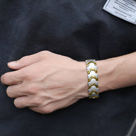Bracelet magnétique homme en acier inoxydable bicolore argent et or à maillons incurvés.