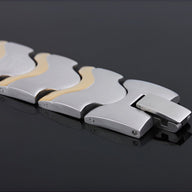 Bracelet magnétique homme en acier inoxydable argent et or, design moderne et géométrique.