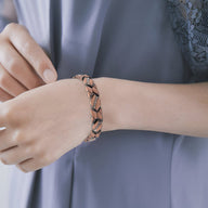 Bracelet magnétique en cuivre bronze avec maillons larges porté au poignet féminin sur chemise grise.