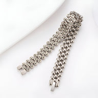 Bracelet masculin en germanium argenté avec motifs circulaires et fermoir métallique robuste.