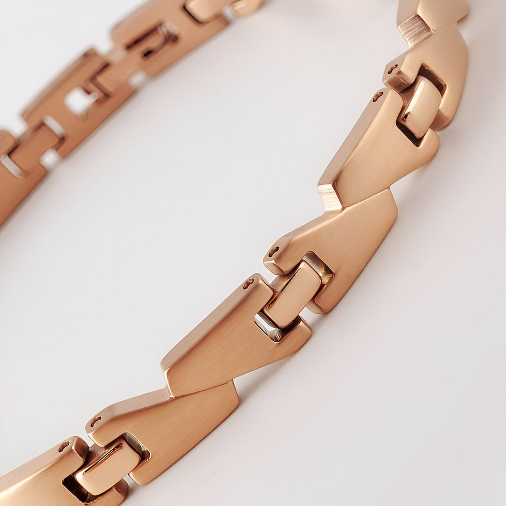 Bracelet magnétique femme en titane or rosé avec maillons géométriques lisses et polis.