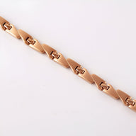 Bracelet magnétique en titane or rosé pour femme avec maillons géométriques élégants.
