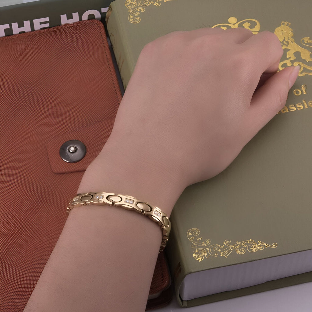 Bracelet magnétique Tyra en titane or avec maillons délicats sur poignet féminin.