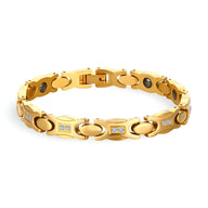 Bracelet magnétique en titane doré pour femme avec maillons ovales et incrustations de cristaux blancs.