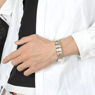 Bracelet magnétique en titane avec maillons argentés et dorés porté au poignet d'un homme.