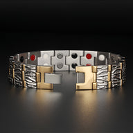 Bracelet magnétique en titane argenté et or pour homme avec motifs gravés et aimants visibles.
