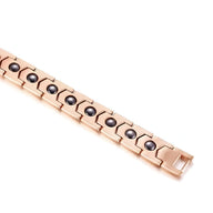 Bracelet magnétique en titane or rosé avec maillons rectangulaires et pastilles noires.