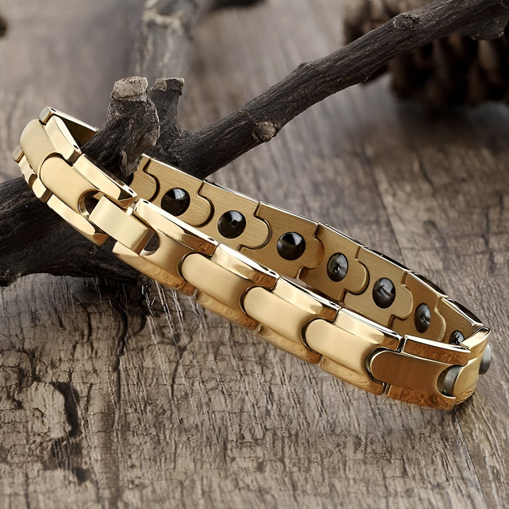 Bracelet magnétique homme en titane couleur or avec maillons larges et pastilles noires visibles à l'intérieur.
