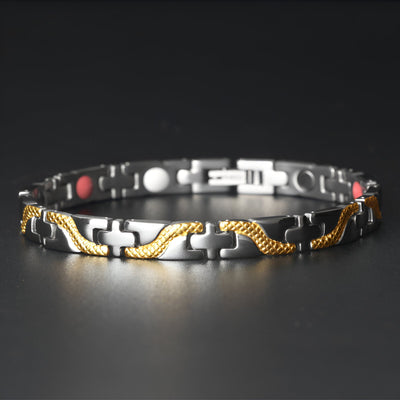 Bracelet magnétique fin en titane noir avec détails torsadés dorés et aimants rouges et blancs.