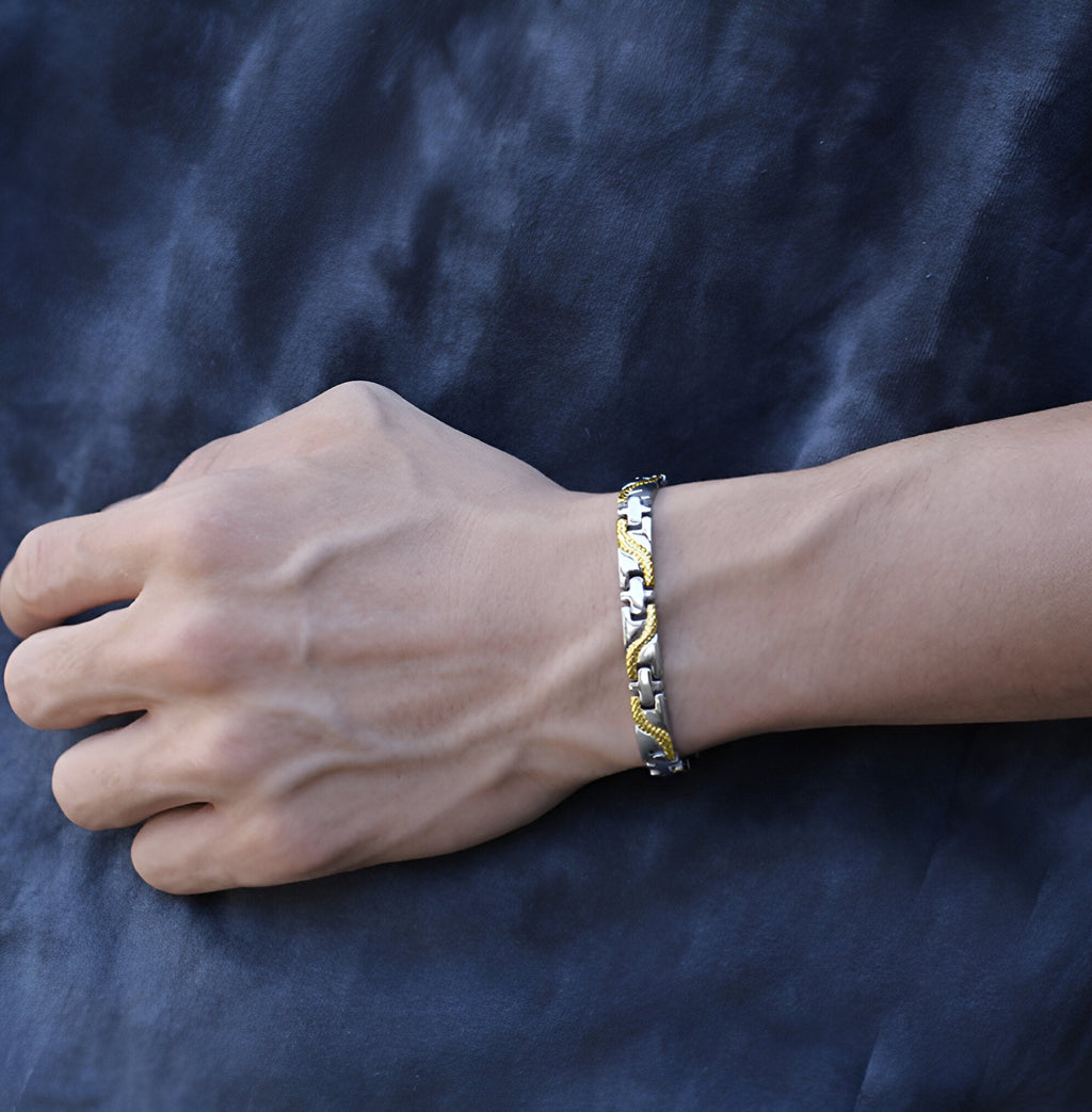 Bracelet magnétique fin en titane bicolore or et argent pour homme, modèle Arne, sur poignet mâle.