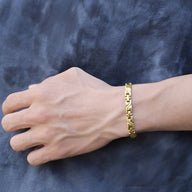 Bracelet magnétique en titane fin doré pour homme avec maillons élégants.
