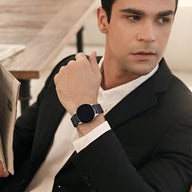 Bracelet magnétique maille milanaise acier inoxydable noir pour Huawei Watch, porté par homme en costume noir.