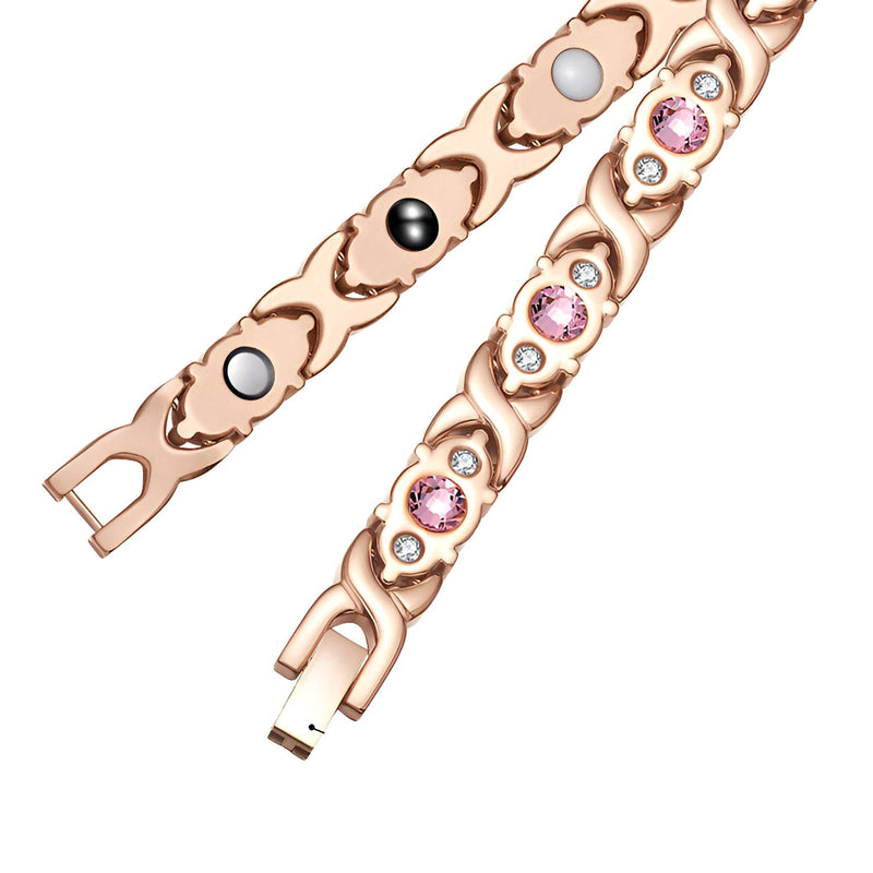 Bracelet magnétique en titane or rosé avec zirconiums roses et éléments magnétiques noirs et blancs.