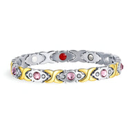 Bracelet magnétique femme en titane argenté et or, serti de zirconiums rose et rouge.