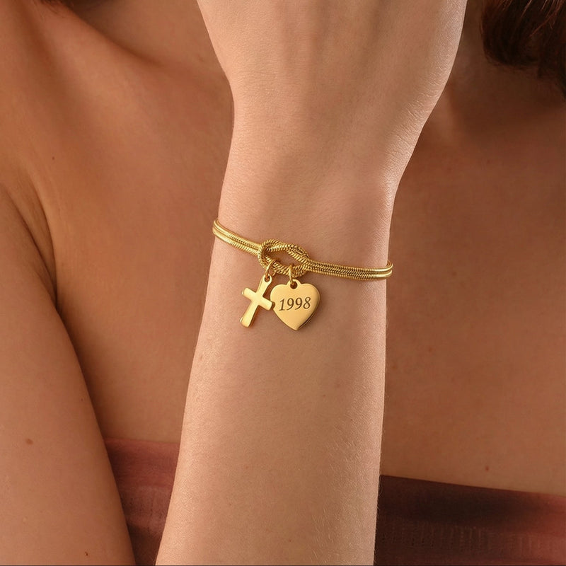 Bracciale a maglia serpente in acciaio inossidabile dorato, nodo centrale simbolico, ciondolo a forma di cuore personalizzabile con incisione e croce delicata, modello Kidé
