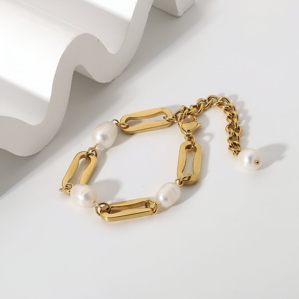 Bracelet en acier inoxydable doré avec maillons épais et perles d'eau douce blanches.