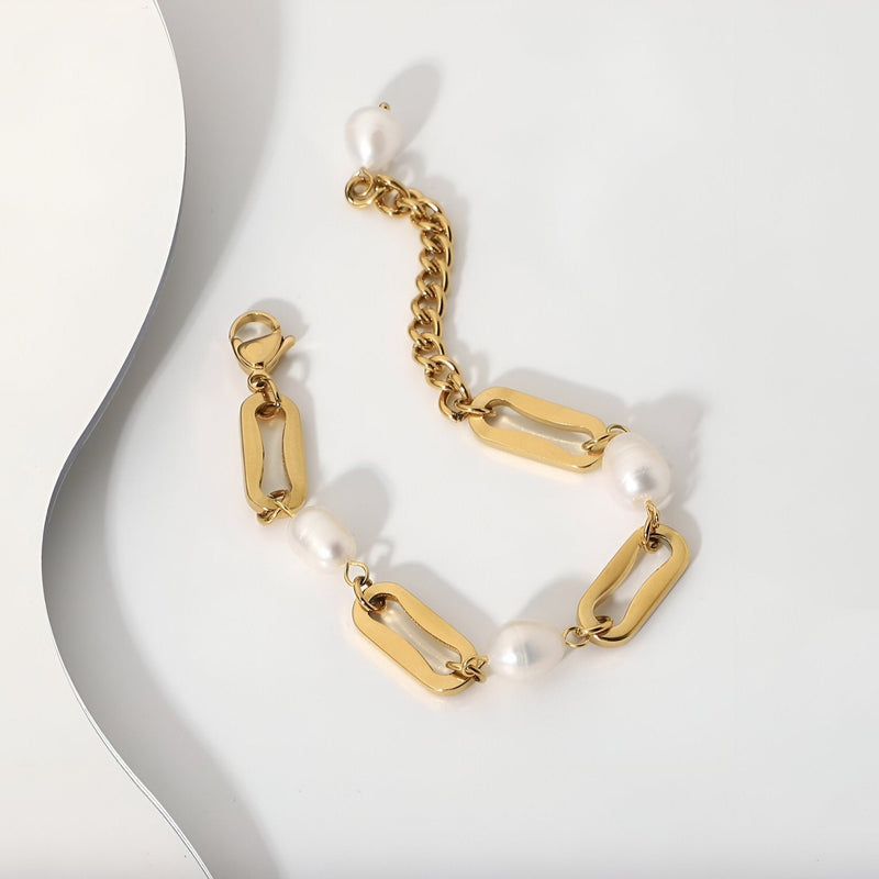 Bracelet femme en acier inoxydable doré avec maillons larges et perles d'eau douce blanches.