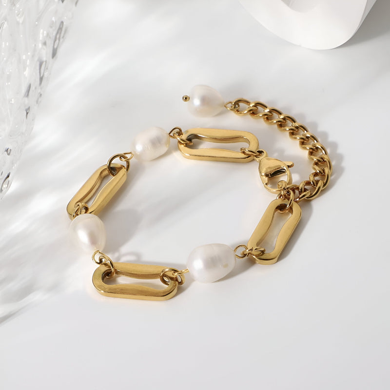 Bracelet doré en acier inoxydable avec maillons épais et perles d'eau douce blanches ovales.