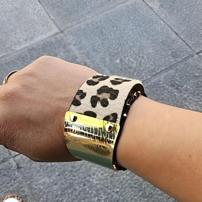 Bracelet manchette femme en cuir beige à motif léopard avec plaque dorée brillante.