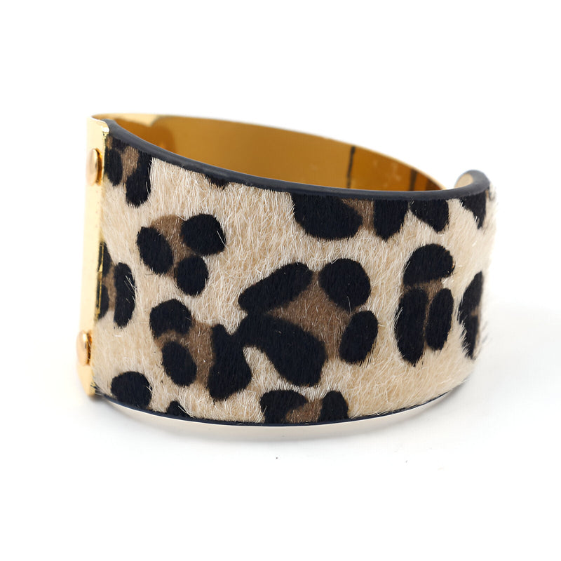 Bracelet manchette en cuir marron motif léopard avec intérieur doré brillant.