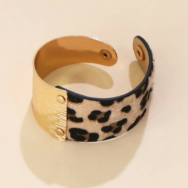 Bracelet manchette femme en cuir marron avec motif léopard et détail doré texturé.
