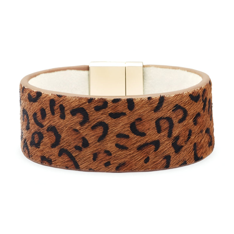 Bracelet manchette large en cuir beige à motif léopard avec fermoir doré magnétique.