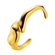 Bracelet manchette en acier inoxydable doré avec design fluide et formes organiques arrondies.